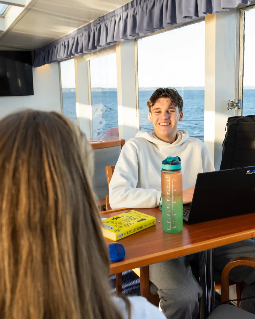 elev i panoramasalong jobber med skolearbeid på PC